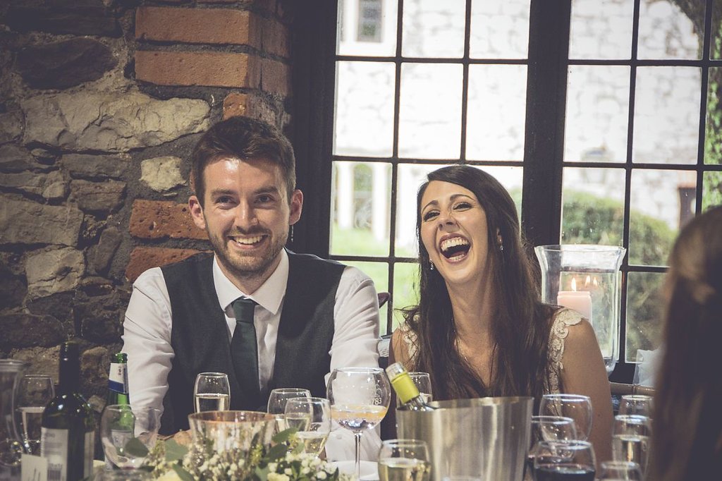 Bride and Groom laughing mid speech at Pencoed House Cardiff
